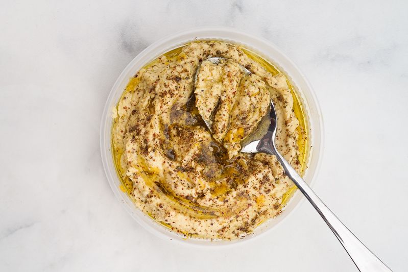 Za'atar Hummus in container with spoon.